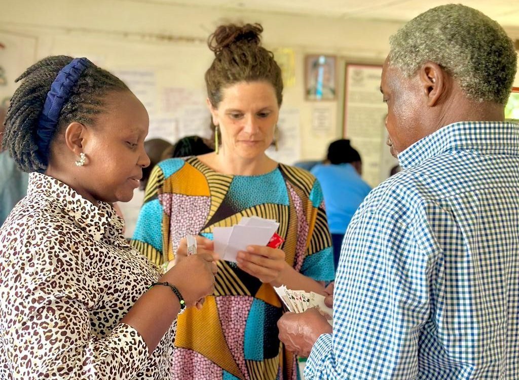 Dr. Mwalimu Musheshe, Eva Murora, and Aude Péronne Engage in Community Asset Voucher Exchange During Workshop's Local Trading Scene